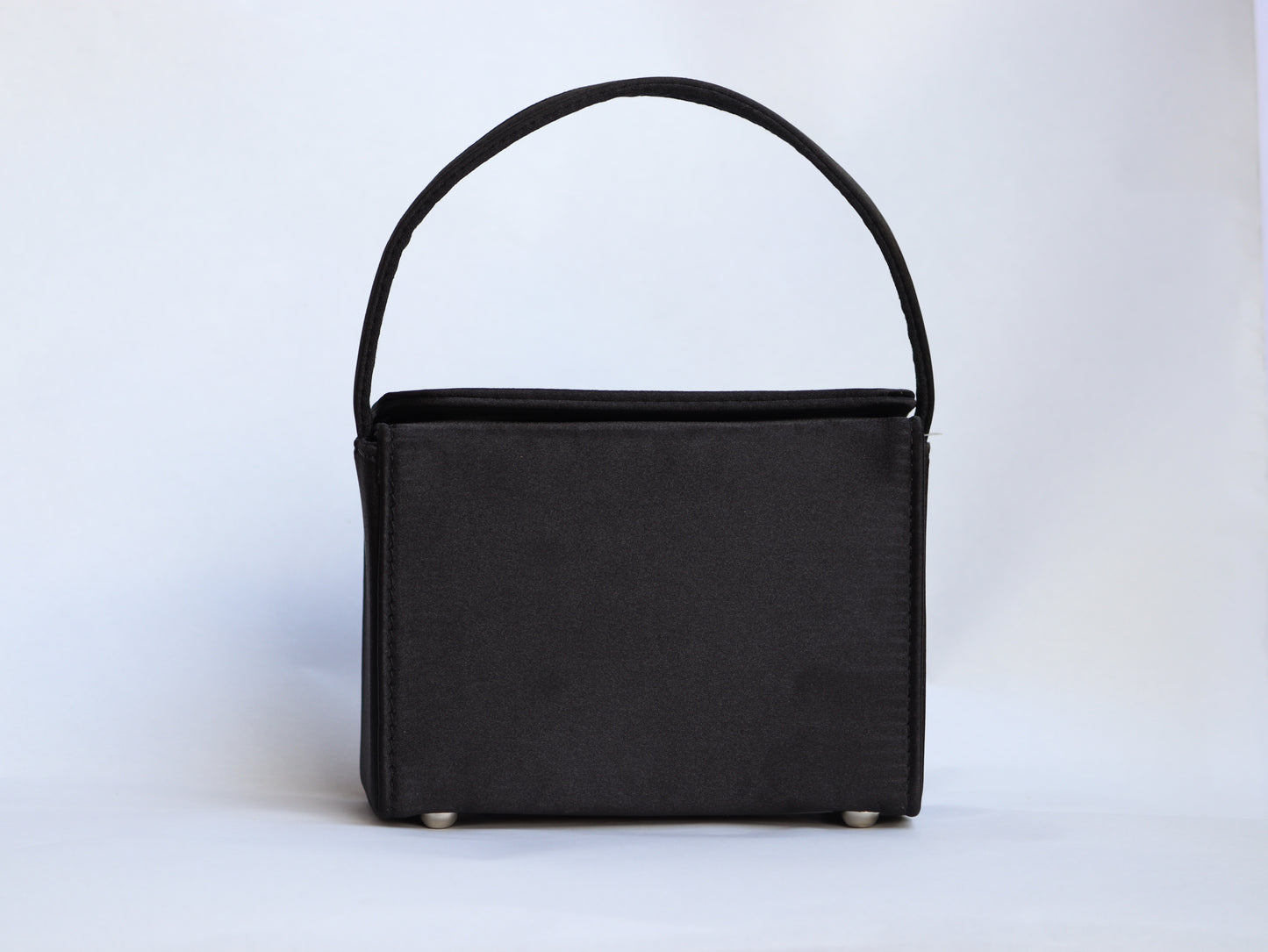 Lily handbag features a sleek black color with a charming butterfly design.