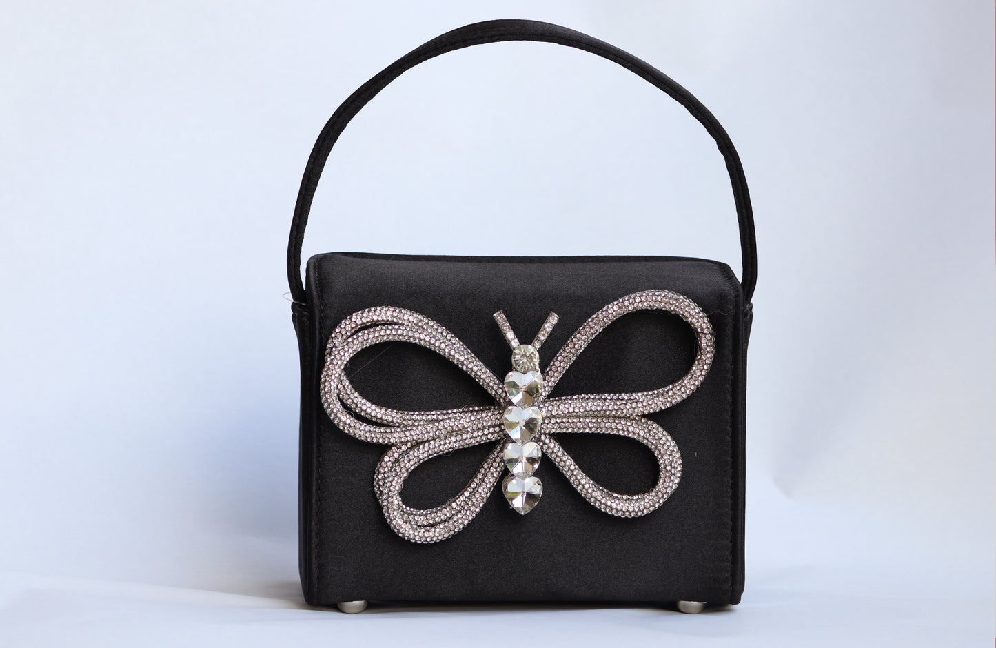 Lily handbag features a sleek black color with a charming butterfly design.