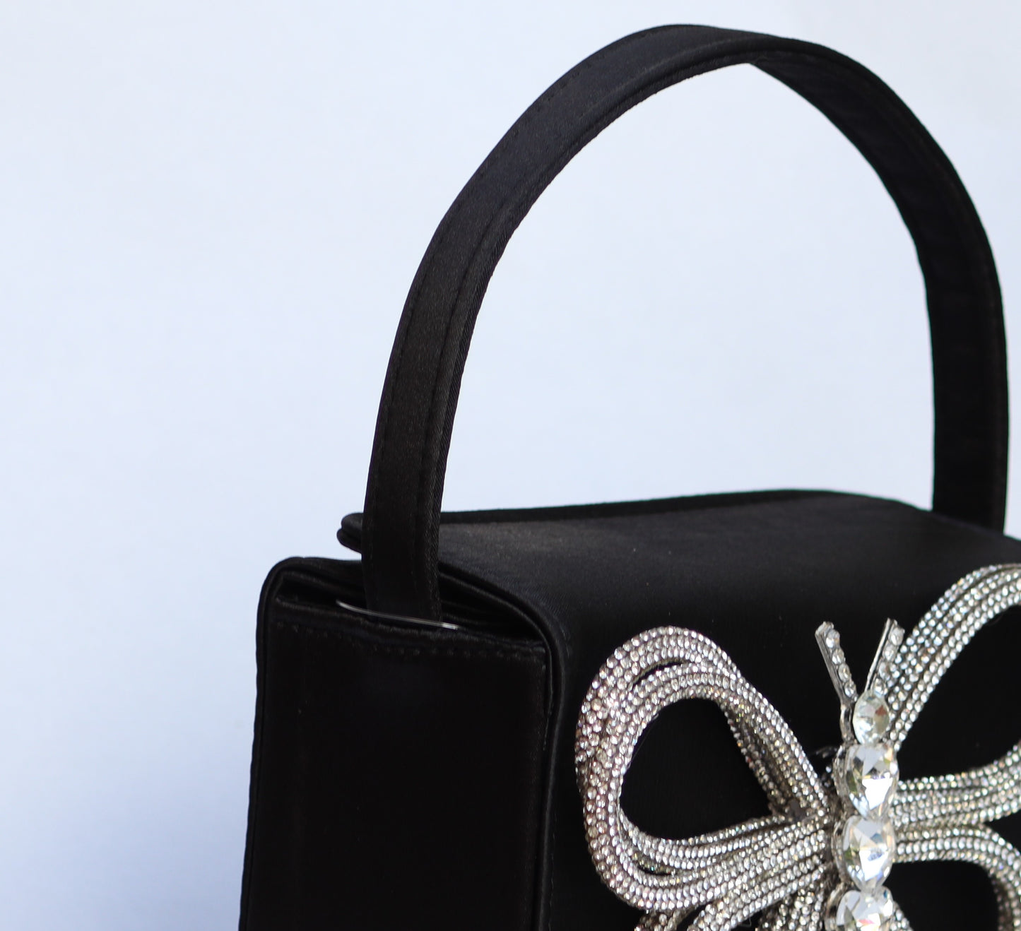 Lily handbag features a sleek black color with a charming butterfly design.