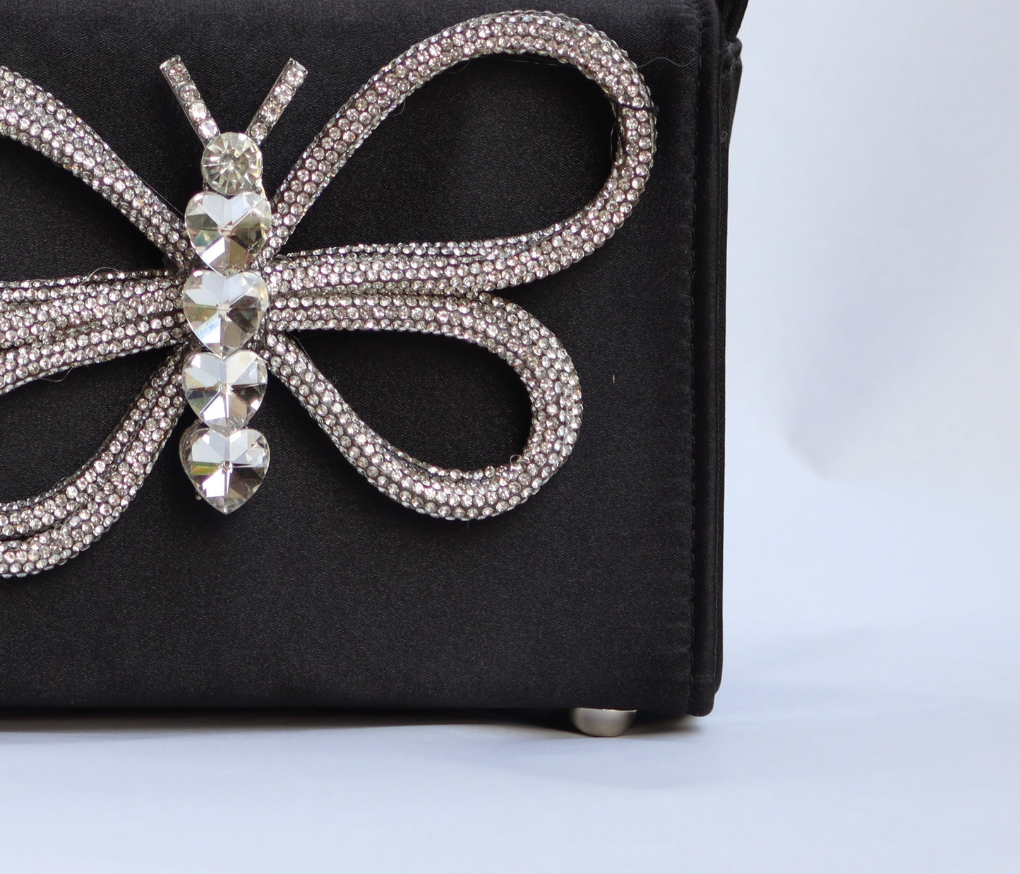 Lily handbag features a sleek black color with a charming butterfly design.